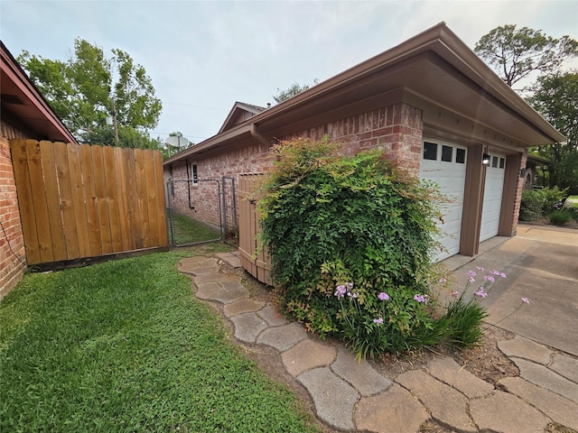 11902 25th St, Santa Fe, TX 77510 - view of property exterior featuring brick siding, a gate, concrete driveway, and an outdoor structure
