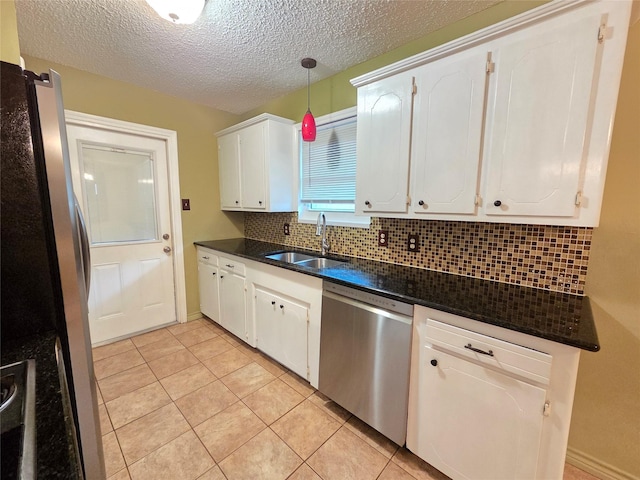 11902 25th St, Santa Fe, TX 77510 - kitchen featuring stainless steel appliances, a sink, white cabinetry, decorative backsplash, and light tile patterned flooring