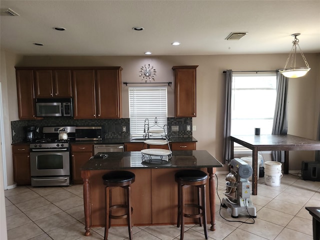 5647 Horseshoe Fls, Missouri City, TX 77459 - kitchen with stainless steel appliances, dark countertops, tasteful backsplash, a breakfast bar, and healthy amount of natural light