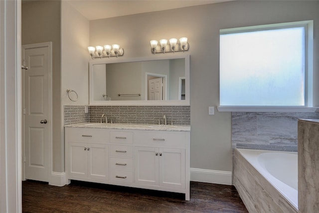 10567 Sunflower Dr, Conroe, TX 77318 - full bathroom featuring double vanity, tasteful backsplash, tiled tub, and wood finished floors