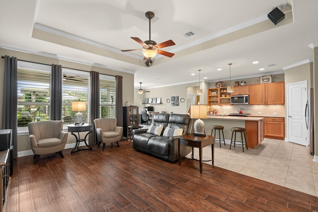 231 Ranch House Ln, Richmond, TX 77469 - living room featuring a tray ceiling, ceiling fan, ornamental molding, recessed lighting, and light wood-style flooring