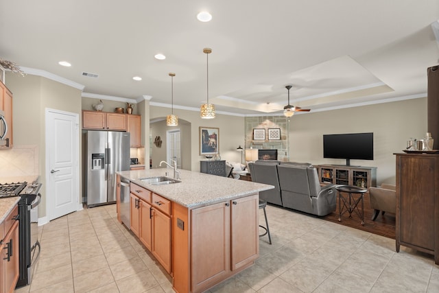 231 Ranch House Ln, Richmond, TX 77469 - kitchen featuring appliances with stainless steel finishes, a ceiling fan, light tile patterned floors, a fireplace, and crown molding