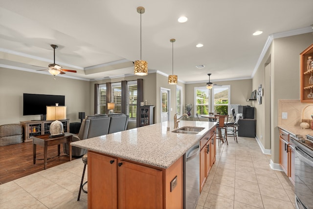 231 Ranch House Ln, Richmond, TX 77469 - kitchen with stainless steel appliances, a ceiling fan, open floor plan, crown molding, and brown cabinets
