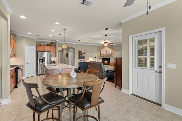 231 Ranch House Ln, Richmond, TX 77469 - dining space featuring a ceiling fan, a fireplace, ornamental molding, recessed lighting, and light tile patterned flooring