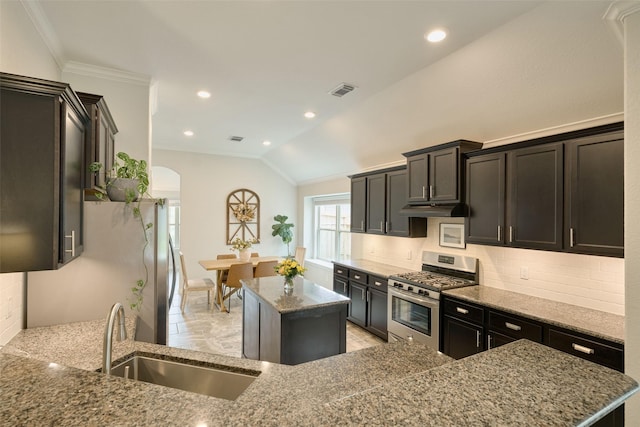 2947 Twin Cove Ct, Conroe, TX 77301 - kitchen with stainless steel appliances, a center island, stone countertops, under cabinet range hood, and crown molding