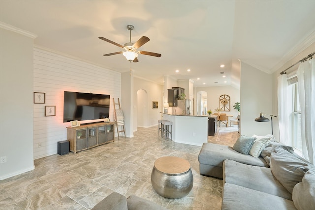 2947 Twin Cove Ct, Conroe, TX 77301 - living area with arched walkways, crown molding, a ceiling fan, wooden walls, and light stone finish flooring