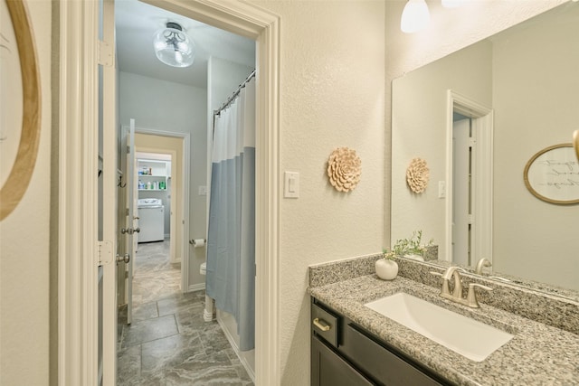 2947 Twin Cove Ct, Conroe, TX 77301 - full bath featuring vanity, marble finish flooring, washer / clothes dryer, a shower with shower curtain, and a textured wall