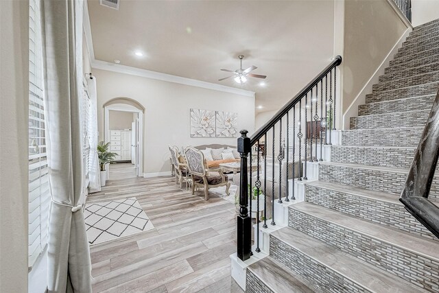 9103 Acorn Harvest Trl, Richmond, TX 77407 - entrance foyer featuring crown molding, ceiling fan, arched walkways, stairs, and wood finished floors