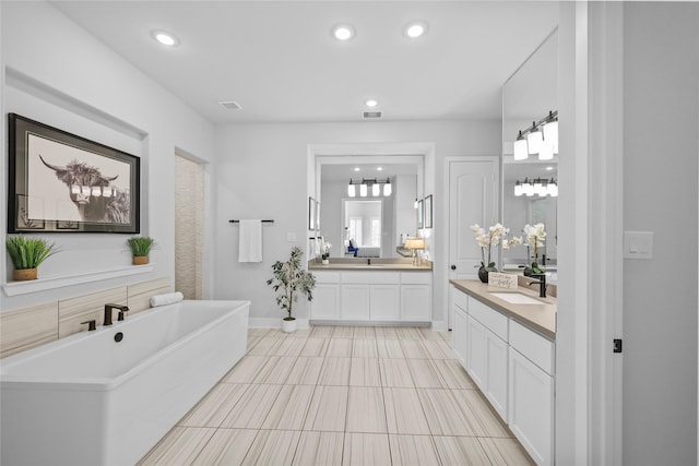 17346 Camillia Trl, Conroe, TX 77302 - bathroom featuring a freestanding bath, two vanities, recessed lighting, tile patterned floors, and baseboards