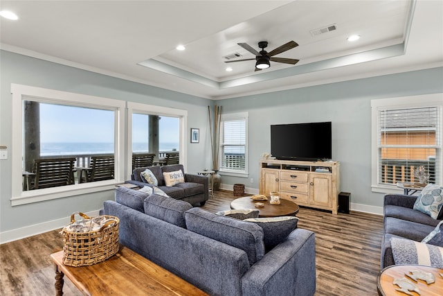 1317 Emerald Dr, Crystal Beach, TX 77650 - living area featuring a raised ceiling, dark wood finished floors, crown molding, baseboards, and ceiling fan