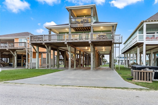 1317 Emerald Dr, Crystal Beach, TX 77650 - coastal inspired home with a carport, a balcony, and a wooden deck