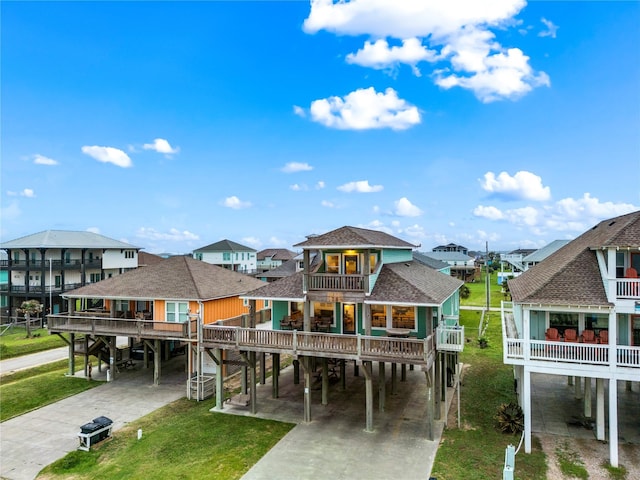 1317 Emerald Dr, Crystal Beach, TX 77650 - rear view of house with a carport, a balcony, driveway, and roof with shingles