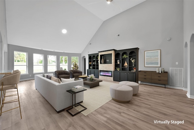 13646 Leafy Arbor Dr, Montgomery, TX 77356 - living area featuring high vaulted ceiling, wood finished floors, arched walkways, recessed lighting, and baseboards