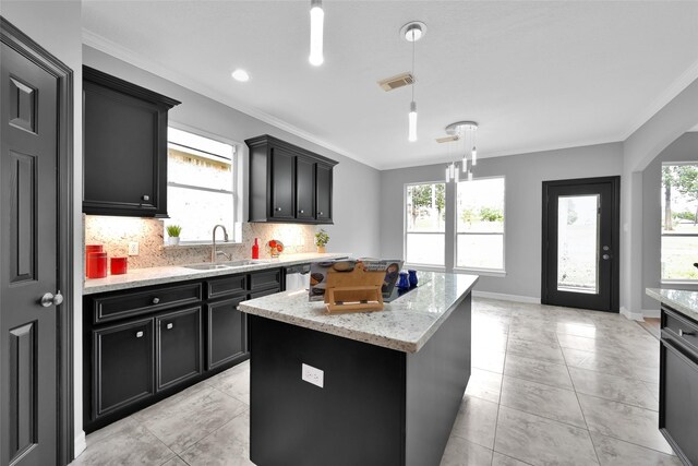 13646 Leafy Arbor Dr, Montgomery, TX 77356 - kitchen with a sink, ornamental molding, a kitchen island, tasteful backsplash, and dark cabinets