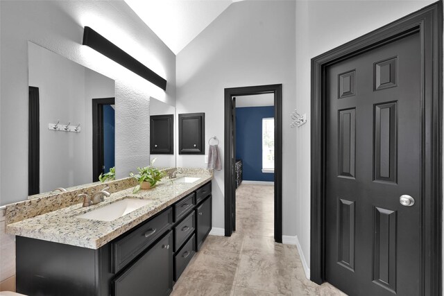 13646 Leafy Arbor Dr, Montgomery, TX 77356 - bathroom featuring vaulted ceiling, double vanity, and baseboards
