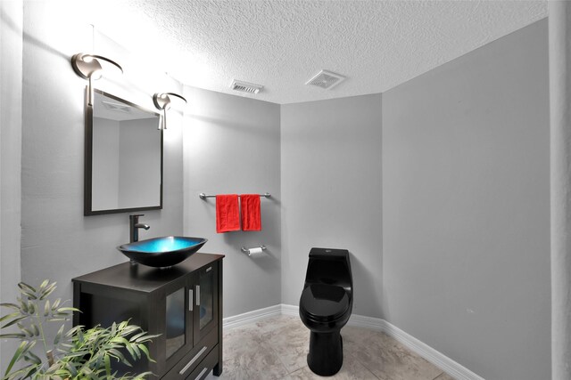 13646 Leafy Arbor Dr, Montgomery, TX 77356 - bathroom featuring toilet, a textured ceiling, vanity, baseboards, and tile patterned flooring