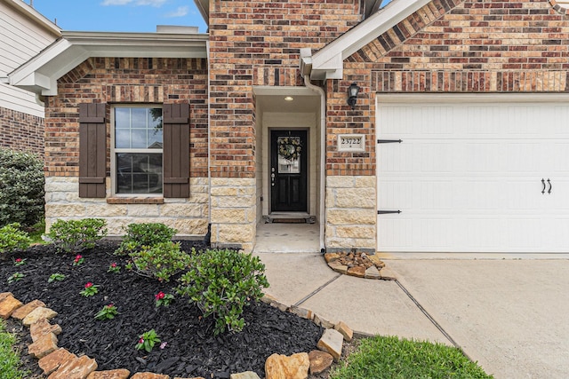 23722 Willow Haven Dr, Spring, TX 77389 - view of exterior entry featuring brick siding, an attached garage, and driveway