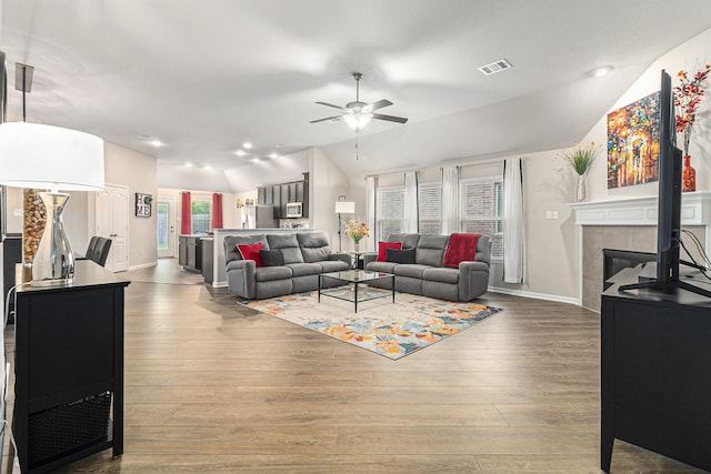 23722 Willow Haven Dr, Spring, TX 77389 - living room featuring vaulted ceiling, a ceiling fan, baseboards, wood finished floors, and a fireplace