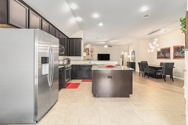 23722 Willow Haven Dr, Spring, TX 77389 - kitchen featuring appliances with stainless steel finishes, a kitchen island, light tile patterned flooring, light stone countertops, and a ceiling fan