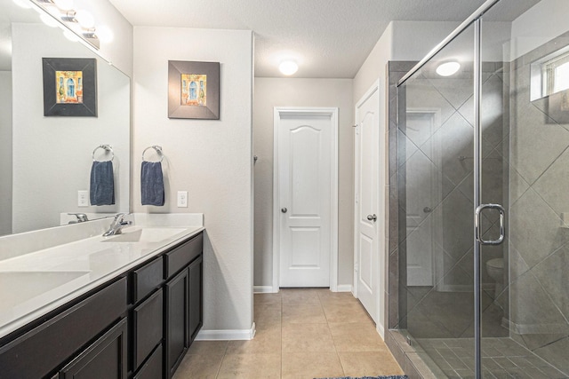 23722 Willow Haven Dr, Spring, TX 77389 - bathroom with double vanity, a shower stall, tile patterned flooring, and baseboards