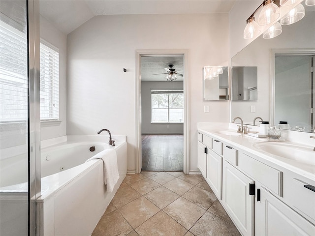 15319 Ochre Leaf Trl, Cypress, TX 77433 - full bathroom featuring double vanity, a jetted tub, ceiling fan, baseboards, and lofted ceiling