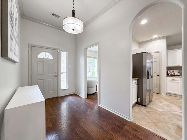 15319 Ochre Leaf Trl, Cypress, TX 77433 - entrance foyer featuring arched walkways, crown molding, light wood-style flooring, and baseboards