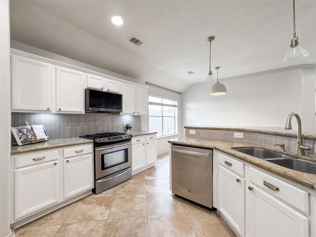 15319 Ochre Leaf Trl, Cypress, TX 77433 - kitchen featuring appliances with stainless steel finishes, a sink, lofted ceiling, tasteful backsplash, and white cabinetry