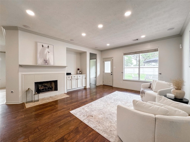 15319 Ochre Leaf Trl, Cypress, TX 77433 - living area featuring crown molding, dark wood finished floors, recessed lighting, a tiled fireplace, and baseboards