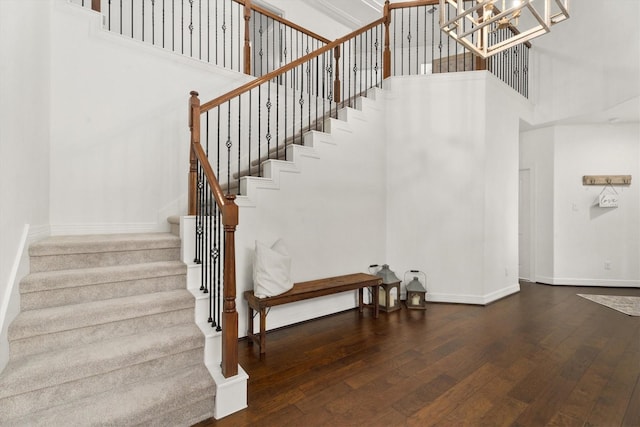 27121 Holtwood Grove Rd, Magnolia, TX 77354 - staircase featuring a towering ceiling, hardwood / wood-style floors, baseboards, and a chandelier