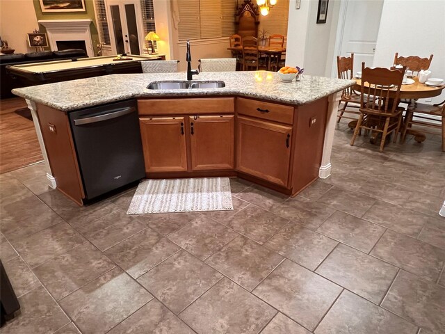 115 Carriage Ct, Magnolia, TX 77354 - kitchen featuring dishwashing machine, a sink, open floor plan, a center island with sink, and light stone counters