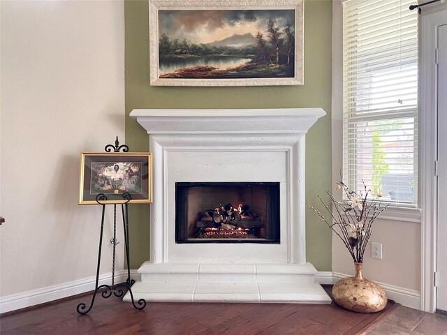 115 Carriage Ct, Magnolia, TX 77354 - detailed view of a warm lit fireplace, baseboards, and wood finished floors
