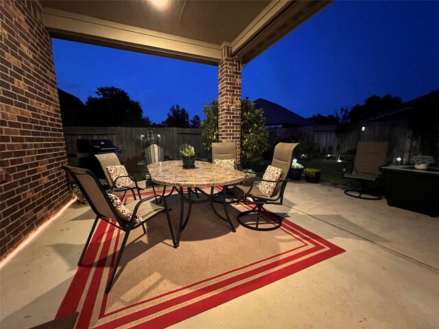 115 Carriage Ct, Magnolia, TX 77354 - patio at twilight with outdoor dining space and a patio