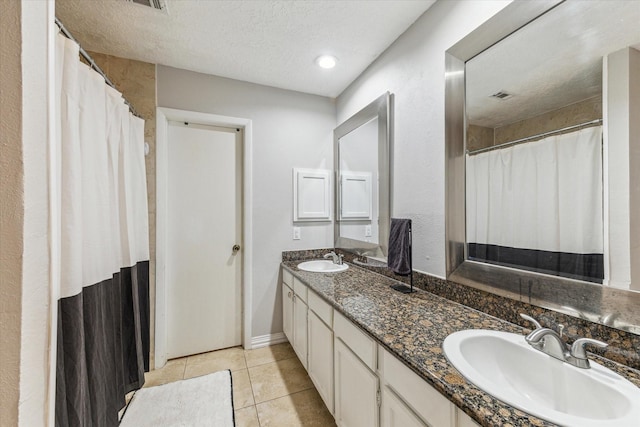 2515 Spring Dusk Ln, Spring, TX 77373 - full bathroom featuring double vanity, tile patterned floors, a textured ceiling, baseboards, and a shower with curtain