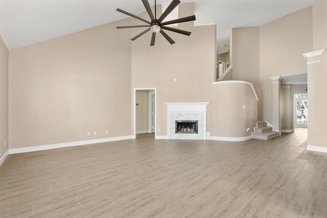 3106 Five Oaks Dr, Missouri City, TX 77459 - unfurnished living room featuring high vaulted ceiling, a ceiling fan, stairs, a fireplace, and wood finished floors