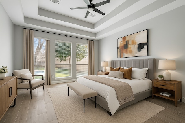 3106 Five Oaks Dr, Missouri City, TX 77459 - bedroom featuring a tray ceiling, light wood-type flooring, and ceiling fan