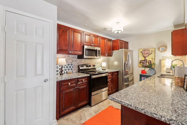 10711 Kirkside Dr, Houston, TX 77096 - kitchen featuring appliances with stainless steel finishes, a sink, and reddish brown cabinets