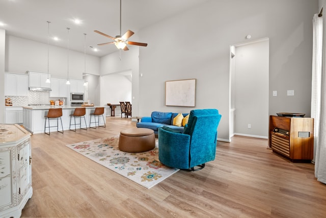 7918 Summit Trail Ln, Porter, TX 77365 - living area featuring ceiling fan, light wood finished floors, a towering ceiling, baseboards, and recessed lighting