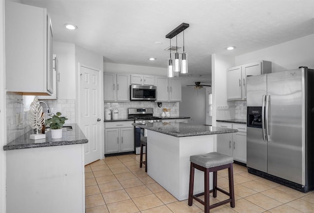 10307 Collin Park, Houston, TX 77075 - kitchen with appliances with stainless steel finishes, a kitchen island, a ceiling fan, light tile patterned floors, and a sink