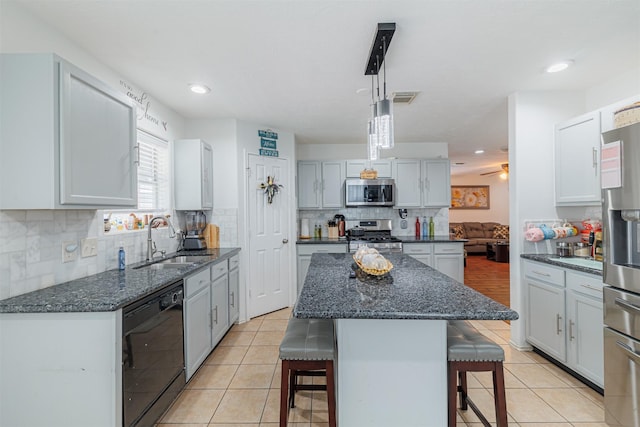 10307 Collin Park, Houston, TX 77075 - kitchen featuring stainless steel appliances, a sink, a kitchen bar, backsplash, and a ceiling fan