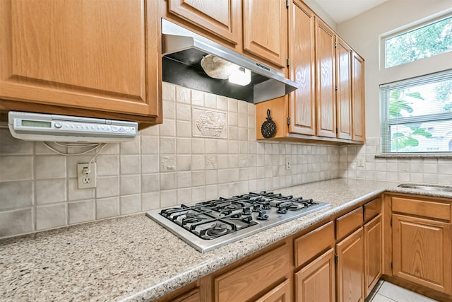 610 Bayou Bend Dr, Deer Park, TX 77536 - kitchen featuring under cabinet range hood, stainless steel gas cooktop, decorative backsplash, and a sink