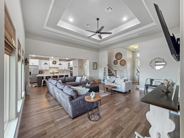 14845 Norma Jane Ln, Beaumont, TX 77713 - living area featuring a ceiling fan, a raised ceiling, stairs, wood finished floors, and a high ceiling