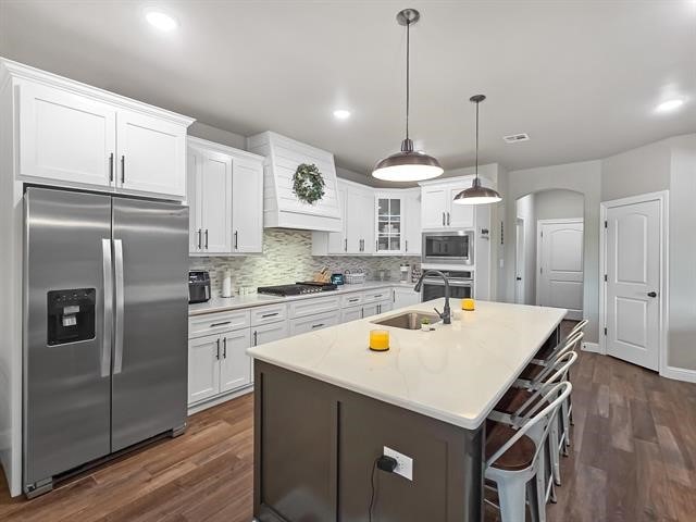 14845 Norma Jane Ln, Beaumont, TX 77713 - kitchen featuring appliances with stainless steel finishes, a sink, dark wood-style floors, white cabinets, and recessed lighting