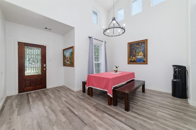 20838 Morgan Knoll Ln, Katy, TX 77449 - dining space with a chandelier, light wood finished floors, a towering ceiling, and baseboards
