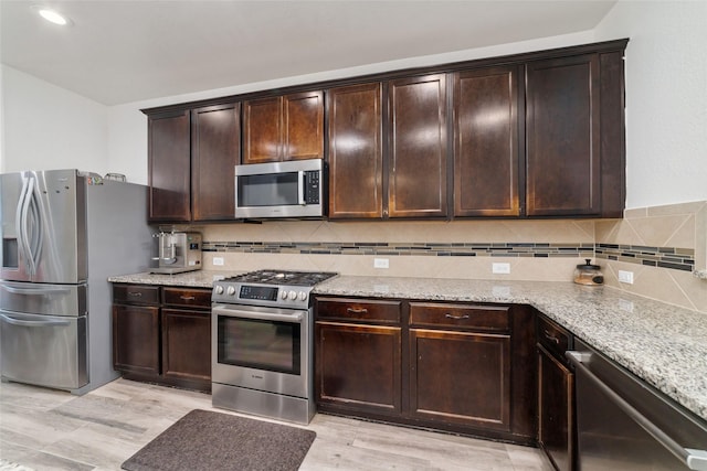20838 Morgan Knoll Ln, Katy, TX 77449 - kitchen with stainless steel appliances, light stone countertops, light wood finished floors, tasteful backsplash, and recessed lighting