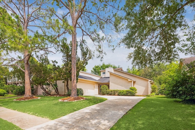 2719 Williams Grant St, Sugar Land, TX 77479 - mid-century home featuring an attached garage, a front lawn, concrete driveway, and brick siding