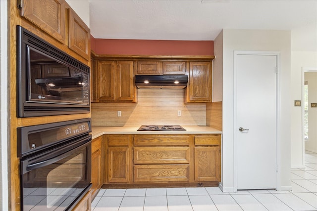 2719 Williams Grant St, Sugar Land, TX 77479 - kitchen with black appliances, under cabinet range hood, light countertops, and light tile patterned floors