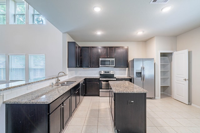 16659 Bluefin St, Crosby, TX 77532 - kitchen featuring stainless steel appliances, a sink, backsplash, light stone counters, and recessed lighting