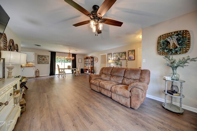 507 Sandra Dr, Brenham, TX 77833 - living room with a chandelier, a ceiling fan, wood finished floors, and baseboards