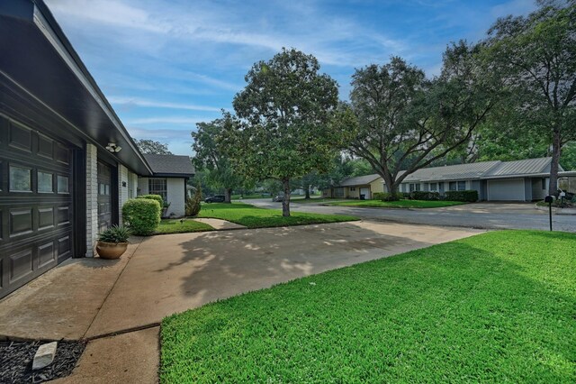 507 Sandra Dr, Brenham, TX 77833 - view of grassy yard with concrete driveway and a garage