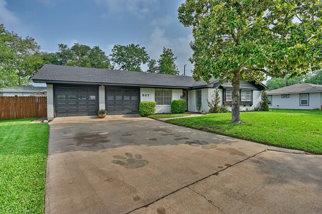 507 Sandra Dr, Brenham, TX 77833 - single story home featuring a garage, brick siding, concrete driveway, and roof with shingles